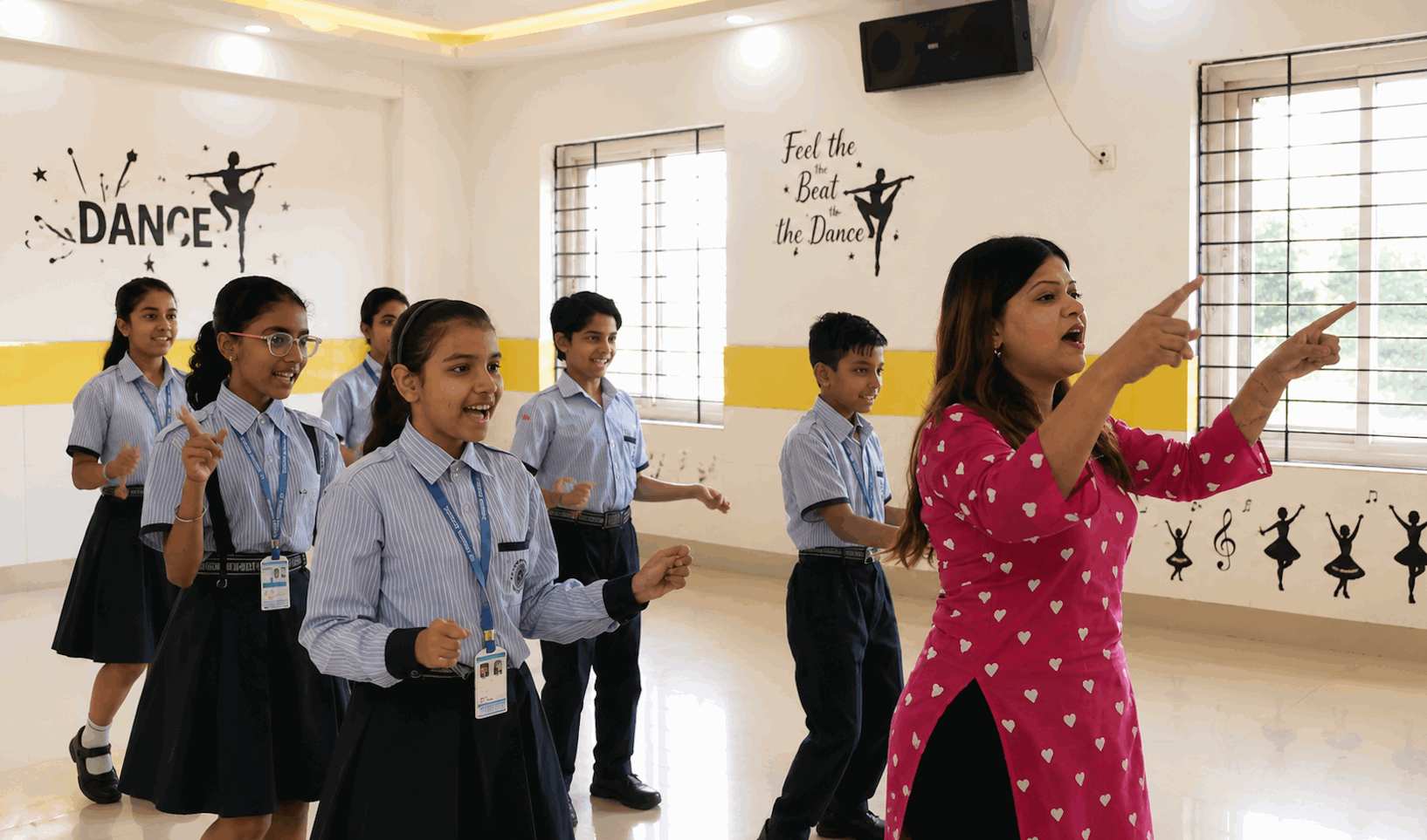 A dance instructor teaching students in the school dance studio