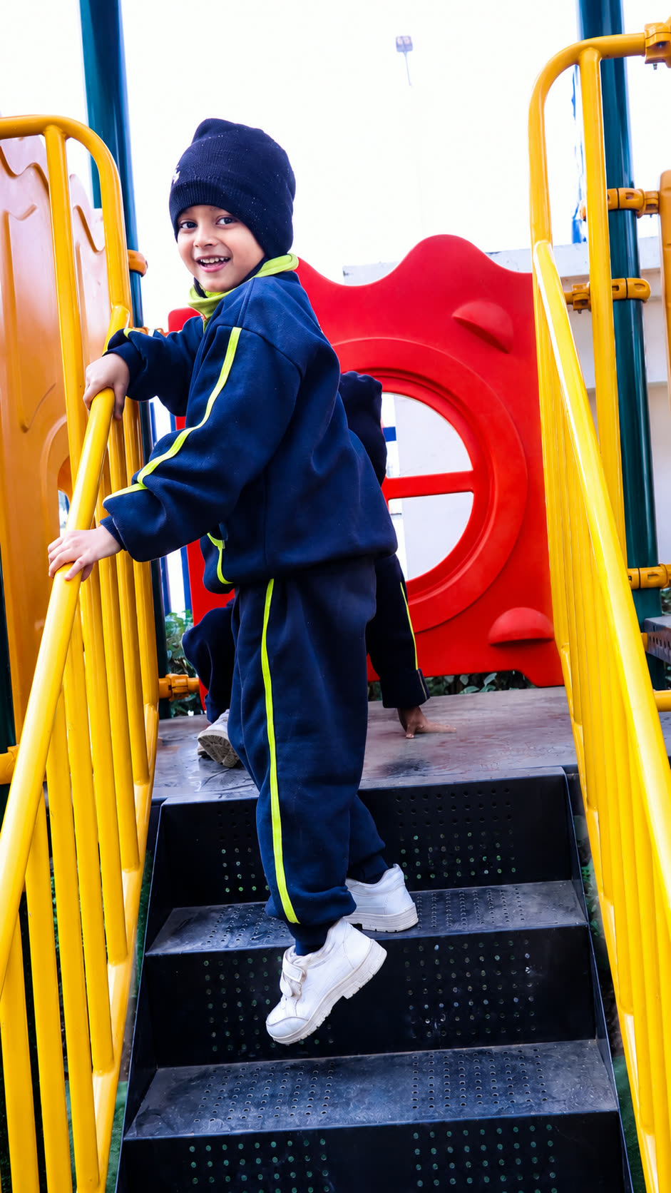 Happy child on colourful playground steps